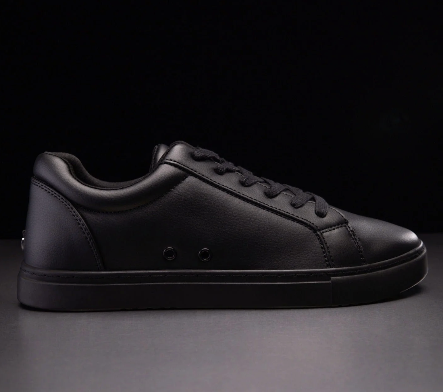 An all-black dance sneaker with black shoe laces - side view